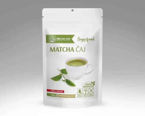 Matcha prah u beloj kesici sa šoljicom pripremljenog matcha napitka i zelenim listom