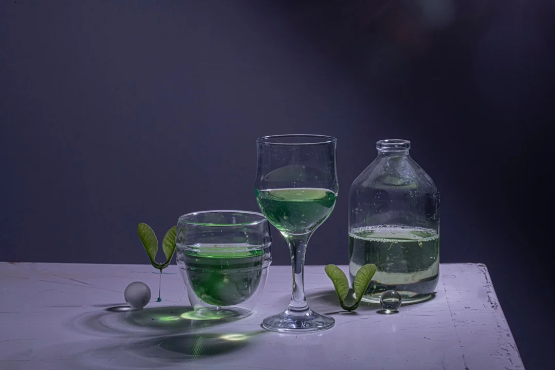 Čaša vode s moringa prahom na svetloj kuhinjskoj površini u jutarnjem svetlu